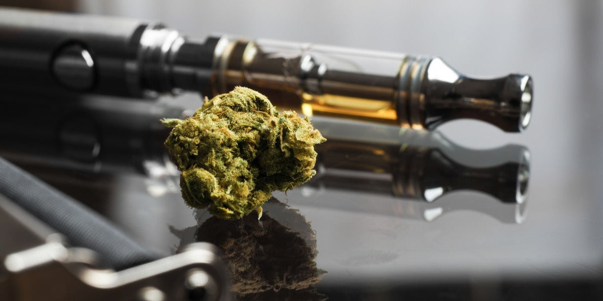 Cannabis kvety vedľa vape kaziet a príslušenstva