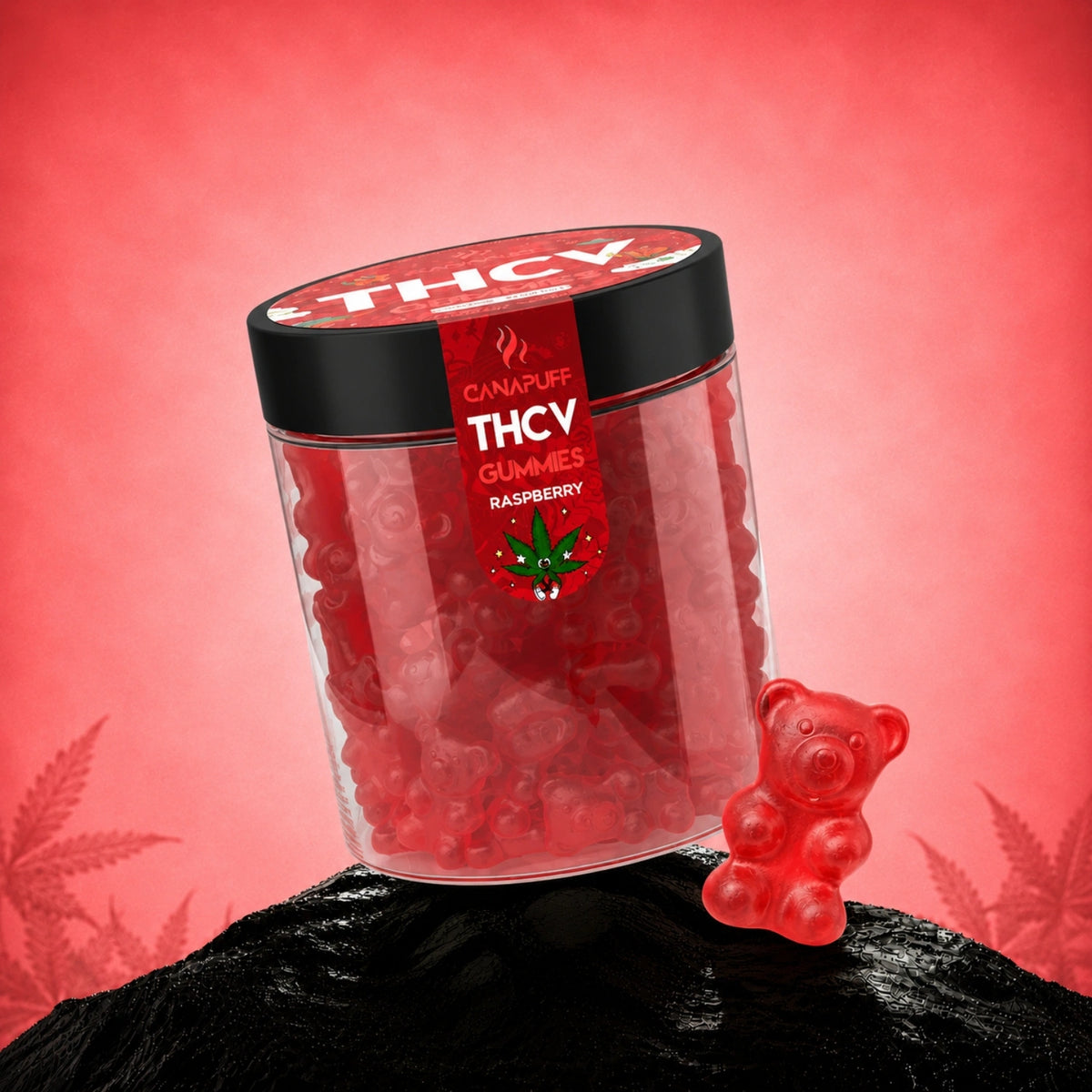 Canapuff THCv Gumíky Raspberry v priehľadnej dóze s čiernym viečkom, červené gumíky a gumový medvedík vedľa na čiernom kameni