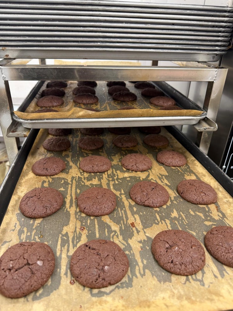 Freshly baked chocolate cookies on baking trays